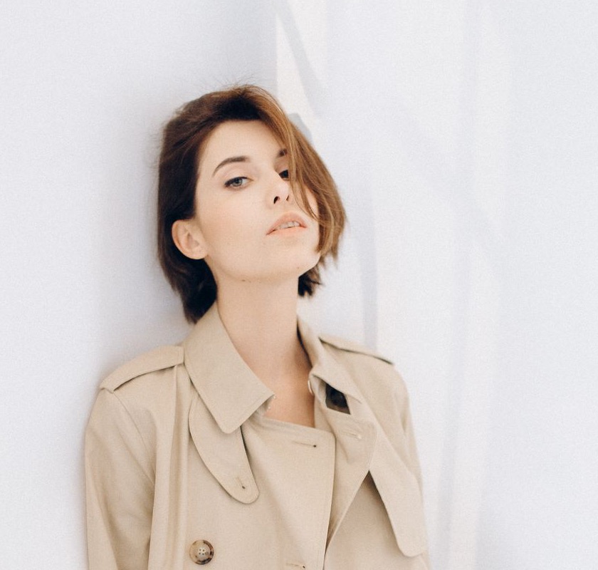 Frau in einem beigen Trenchcoat